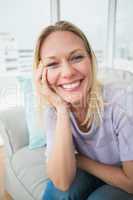 Smiling woman sitting on sofa in living room