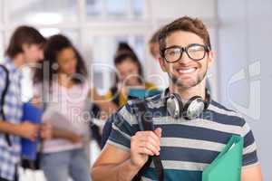 Male student holding folder in college