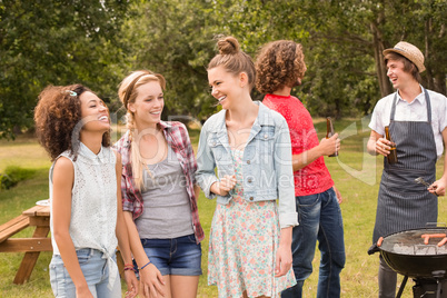 Happy friends in the park having barbecue