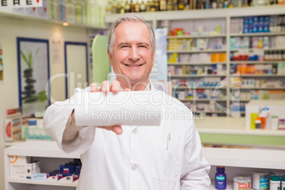 Smiling senior pharmacist showing paper