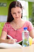 Female student doing homework in library