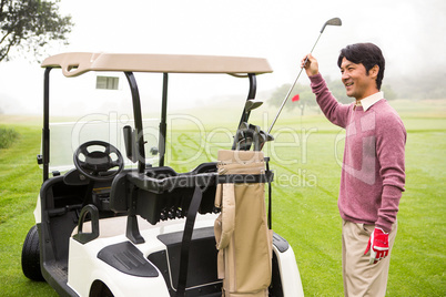 Golfer taking club in golf bag