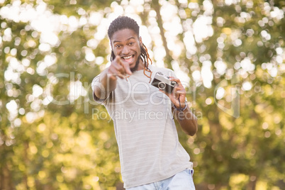 Handsome hipster using vintage camera