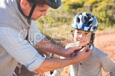 Father clipping on sons helmet