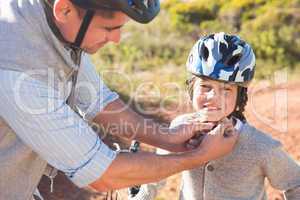 Father clipping on sons helmet