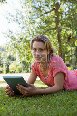 Pretty woman using tablet in park