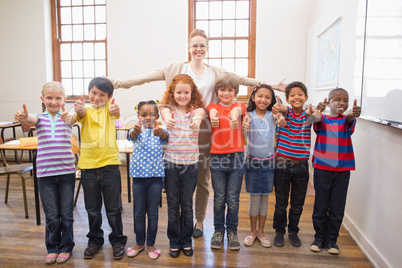 Teacher and pupils smiling at camera in classroom