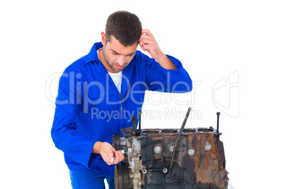 Confused mechanic repairing car engine