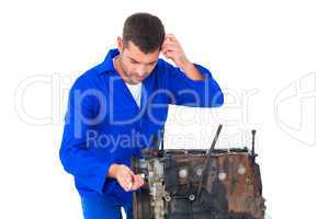 Confused mechanic repairing car engine