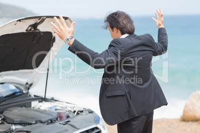 Anger businessman looking at engine