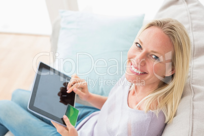 Woman doing online shopping on digital tablet in living room