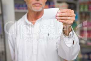 Senior pharmacist holding calling card