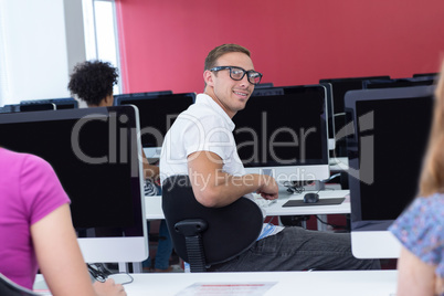 Student smiling at camera in computer class