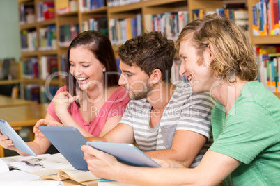 College students using digital tablets in library