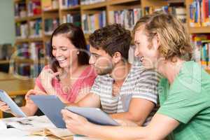 College students using digital tablets in library
