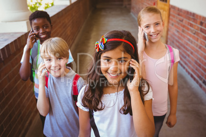 School kids using cellphones in school corridor