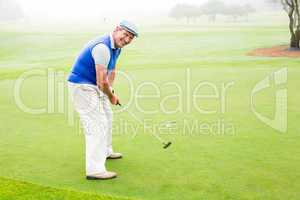 Happy golfer cheering on putting green