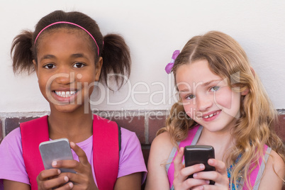 Cute pupils using mobile phone