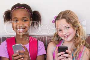 Cute pupils using mobile phone