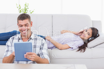 Tablet computer while woman listening music on headphones