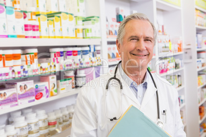 Smiling doctor with stethoscope holding notebooks