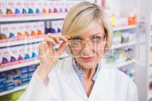 Smiling pharmacist holding her glasses