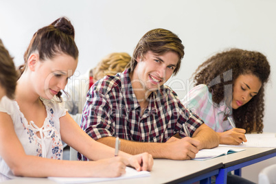 Students writing notes in classroom