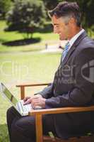 Businessman using laptop in the park