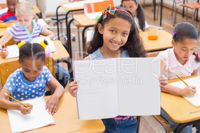 Cute pupil smiling at camera during class presentation