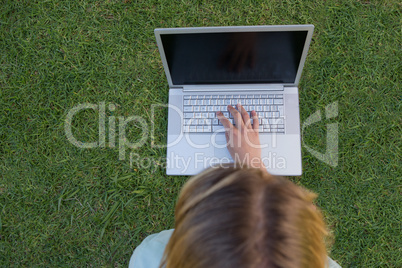 Pretty woman using laptop in park