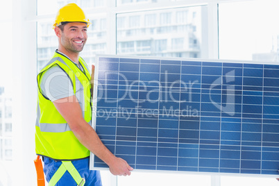 Manual worker carrying solar panel at office
