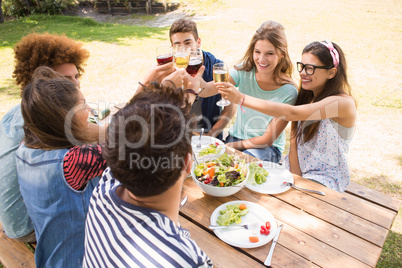 Happy friends in the park having lunch