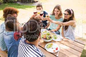 Happy friends in the park having lunch