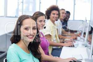 Smiling students using headsets in computer class