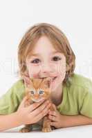 Cute boy with kitten over white background