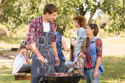 Happy friends in the park having barbecue