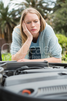 Thoughtful woman looking at engine