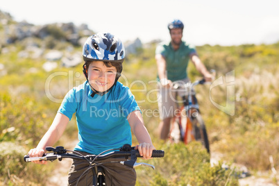 Father and son biking through mountains