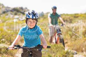 Father and son biking through mountains