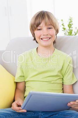 Happy boy using digital tablet on sofa