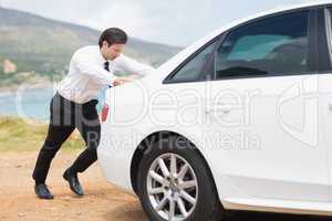 Businessman pushing his car