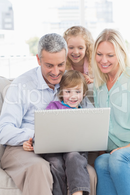 Family of four using laptop