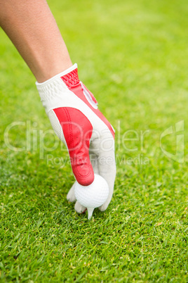 Golfer placing golf ball on tee