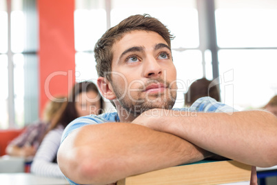 Thoughtful student with books in classroom