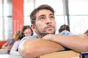 Thoughtful student with books in classroom