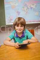 Little boy using digital tablet in classroom