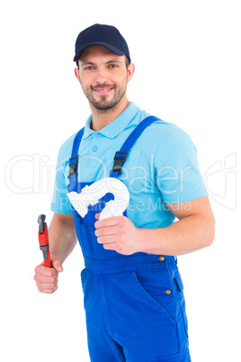Handsome male plumber holding sink pipe