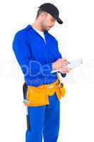 Handyman in blue overall writing on clipboard