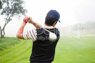 Golfer teeing off