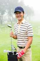 Happy golfer taking club from golf bag